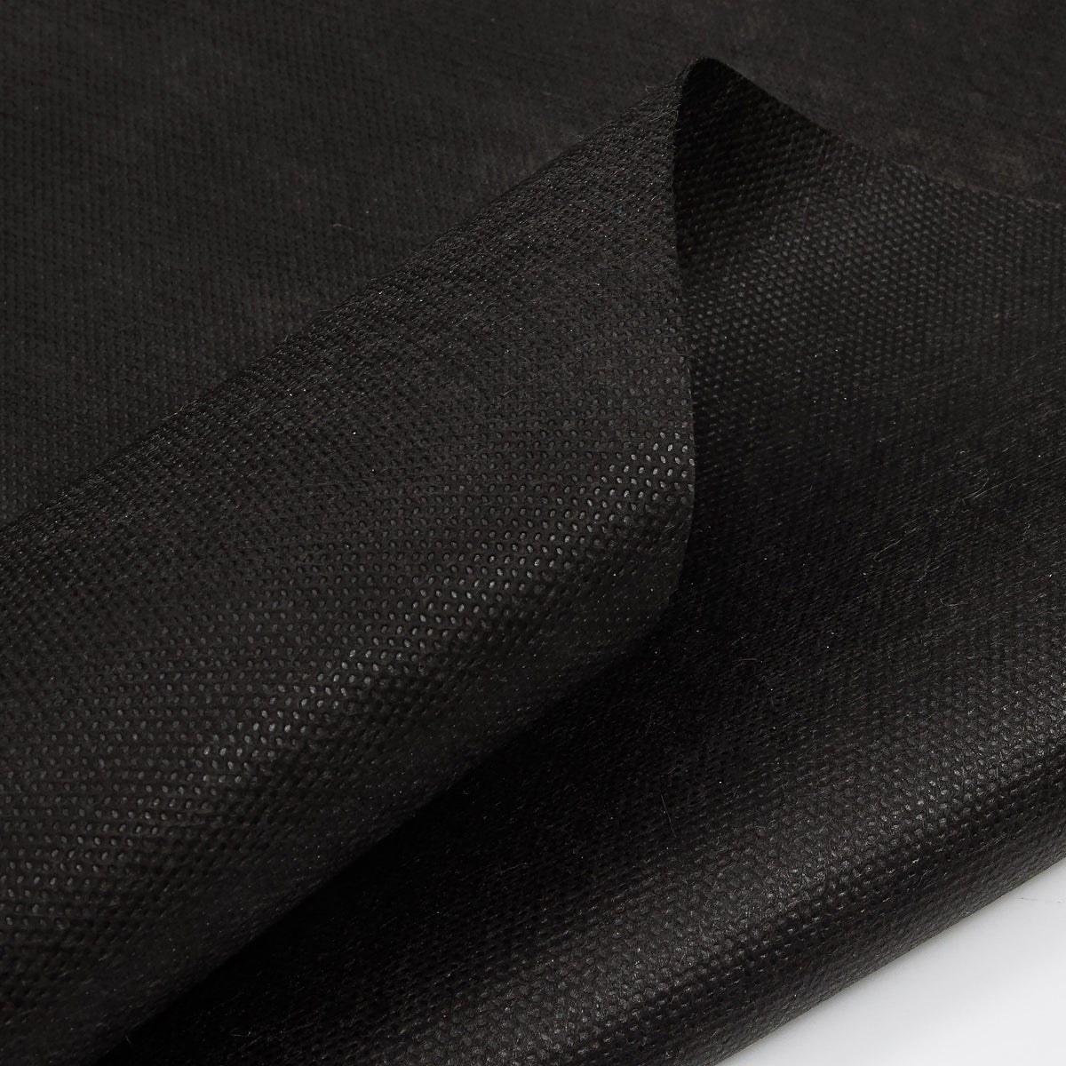 Close-up of the bonded texture of black non-woven spunbond polypropylene fabric
